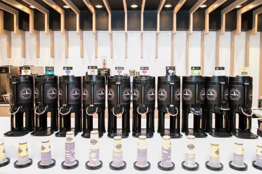 A row of coffee urns at a Marcello's Market & Deli coffee bar
